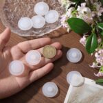 A close-up view of ten white, round silicone stopper plugs, neatly arranged, designed for water bottle lids.