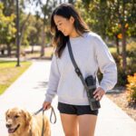 EasyAcc Universal Water Bottle Carrier Sling in black, shown holding a water bottle, with both shoulder strap and carabiner v